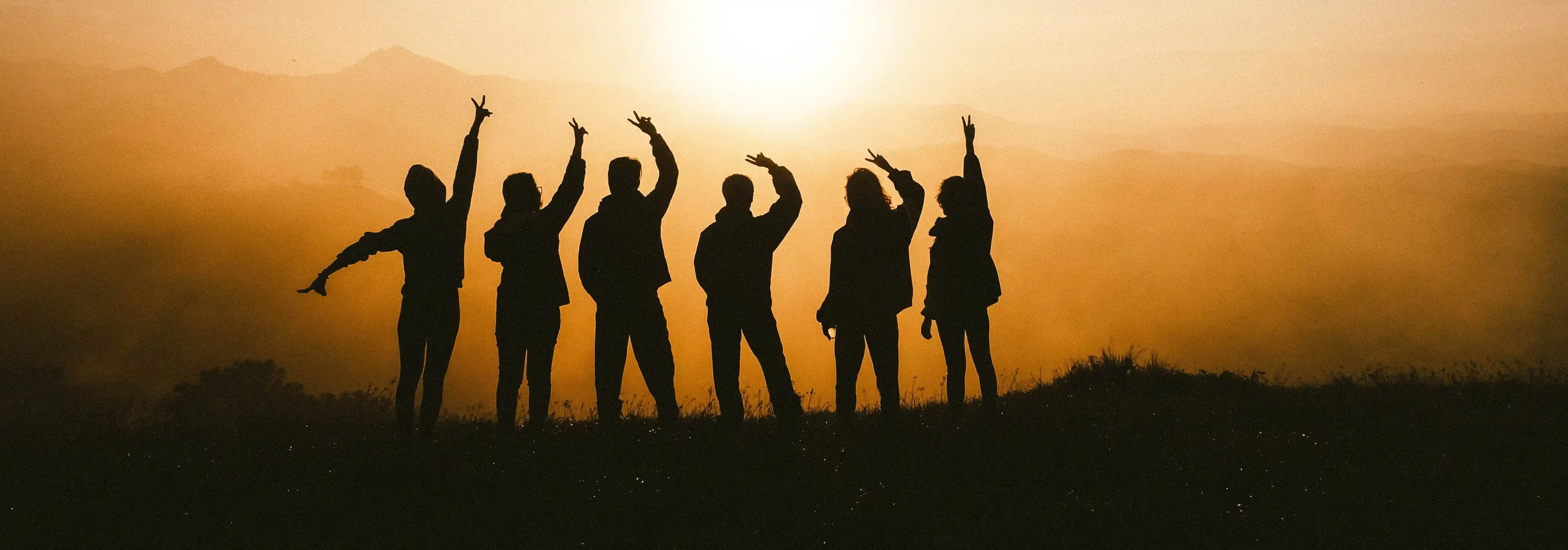 siloheutte of some of our team facing the sunset with a mountainous background